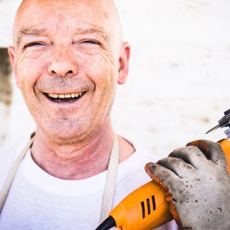 Handwerker mit Elektrowerkzeug bei Reparaturarbeiten